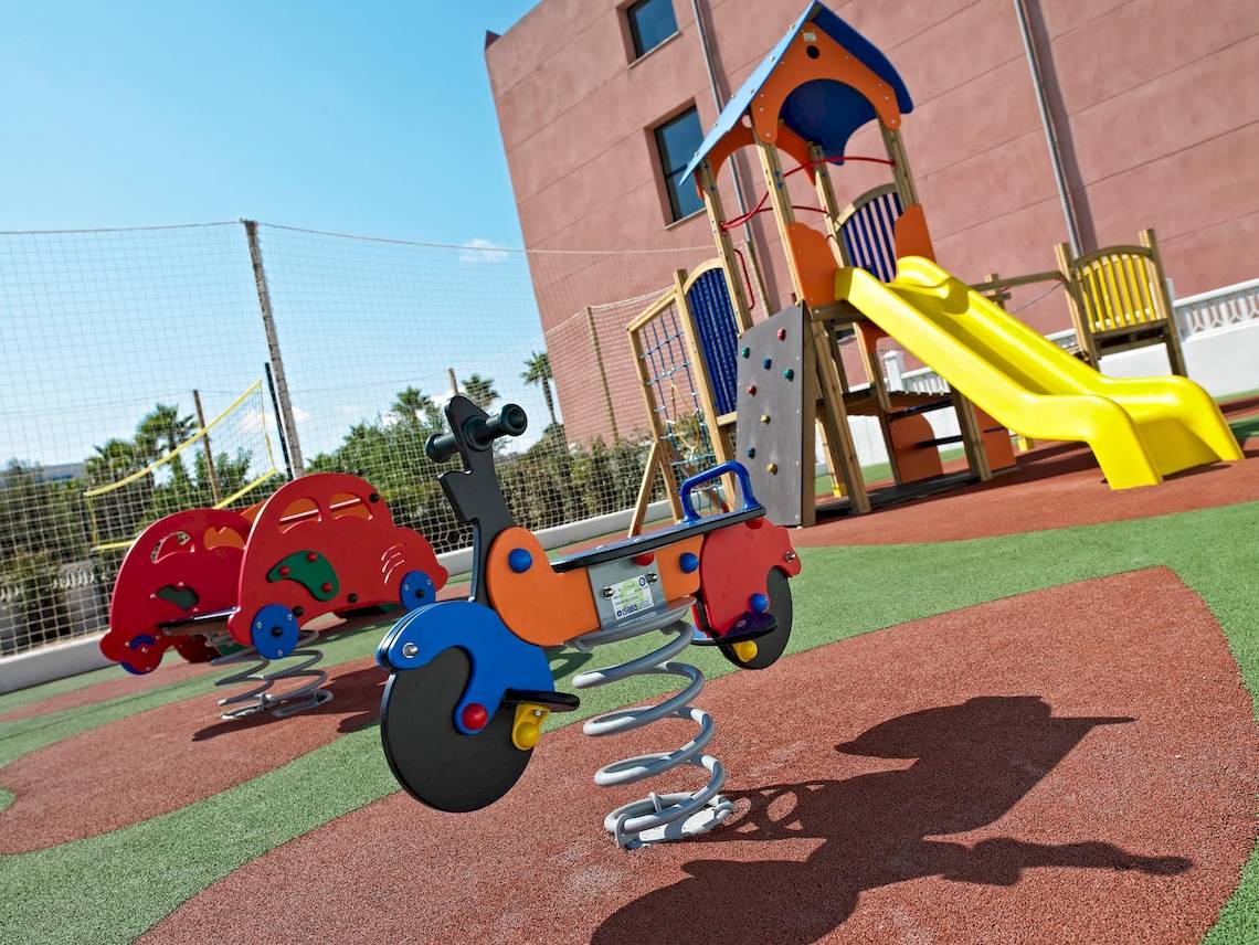Kinderspielplatz im Hipotels Cala Millor Park mit Rutsche und Autos.
