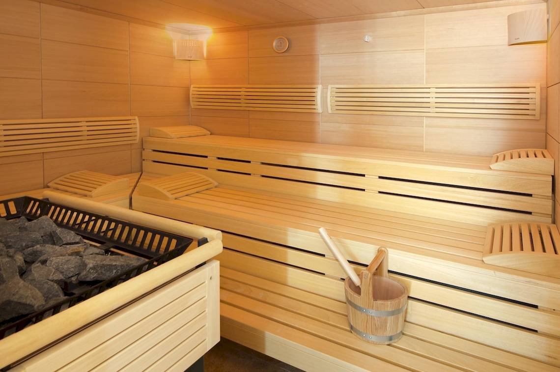 Innenansicht der Sauna im Hipotels Cala Millor Park Hotel mit Holzbänken und Fässern.