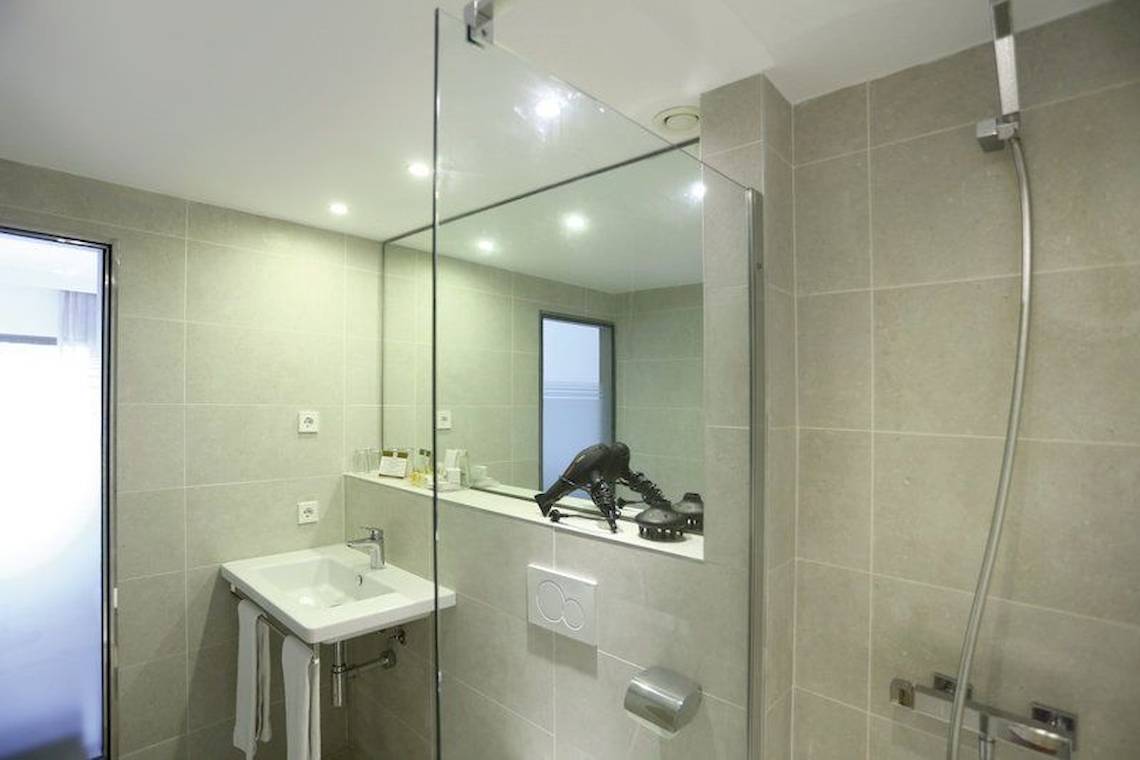 Badezimmer des Playa Golf Hotel mit Glasdusche, Waschbecken und Spiegel