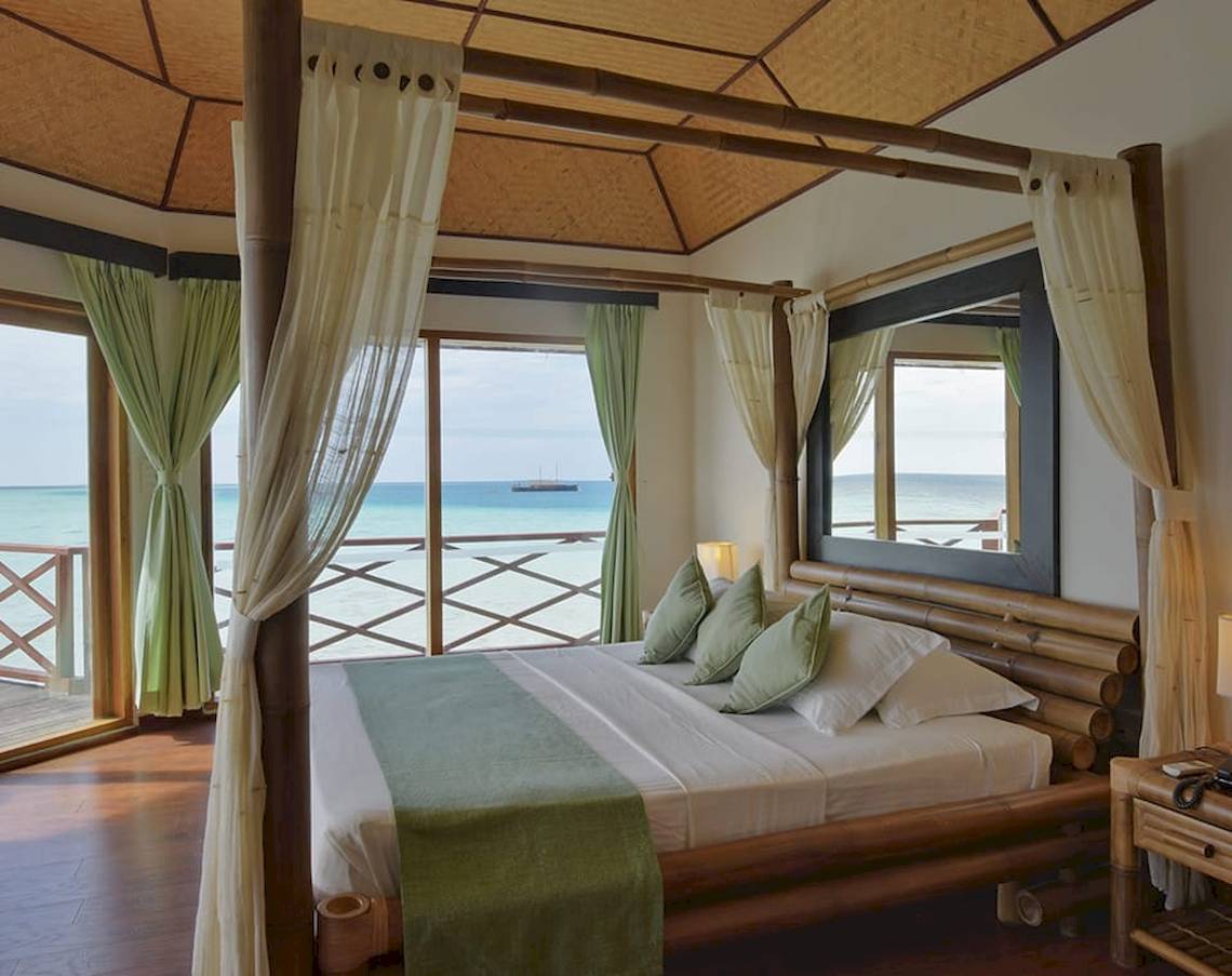 Innenansicht eines Schlafzimmers im Safari Island Resort mit Blick auf das Meer.