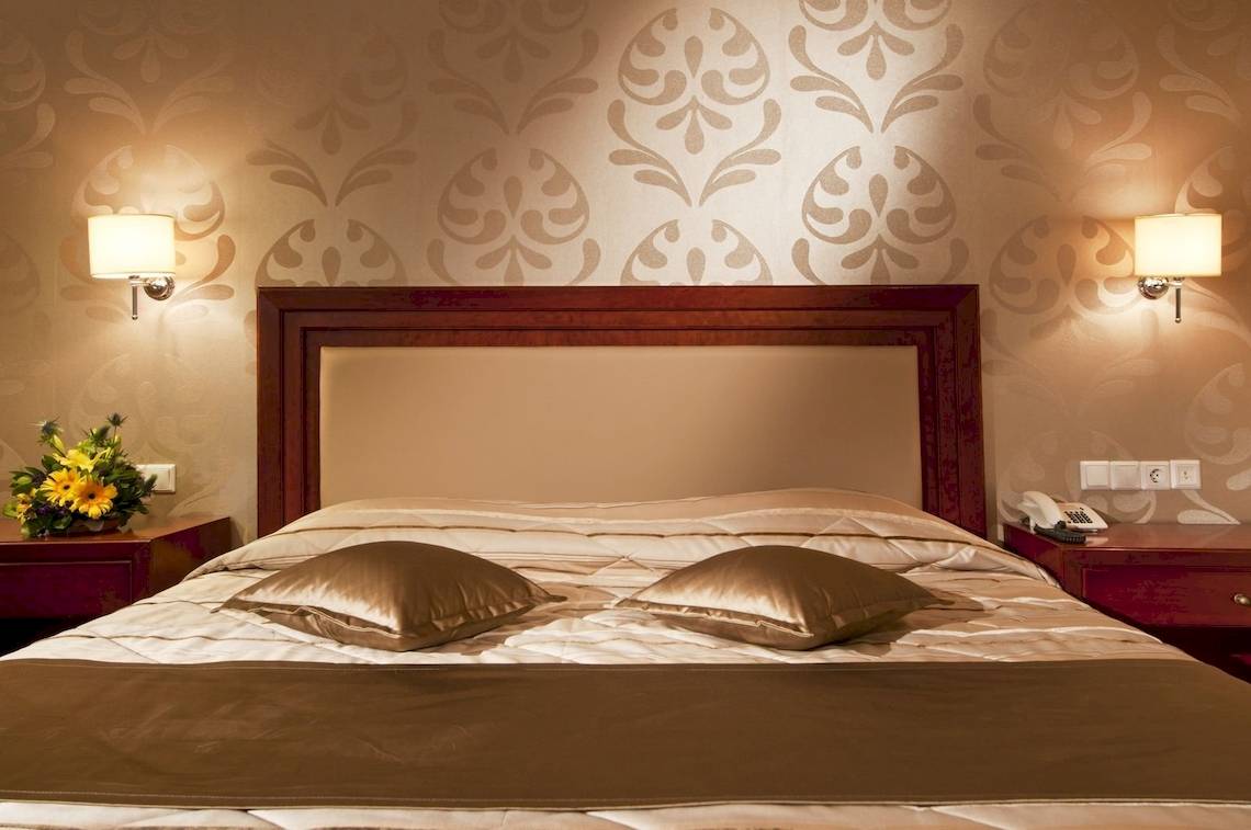 Hotelzimmer im Kipriotis Village Resort mit Doppelbett, zwei Kissen und Nachttischen.