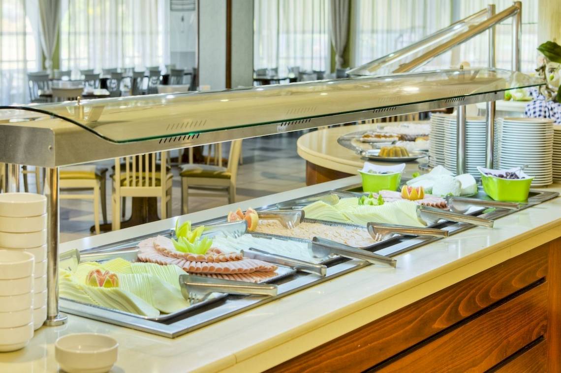 Frühstücksbuffet im Kipriotis Village Resort mit verschiedenen Lebensmitteln und Geschirr.