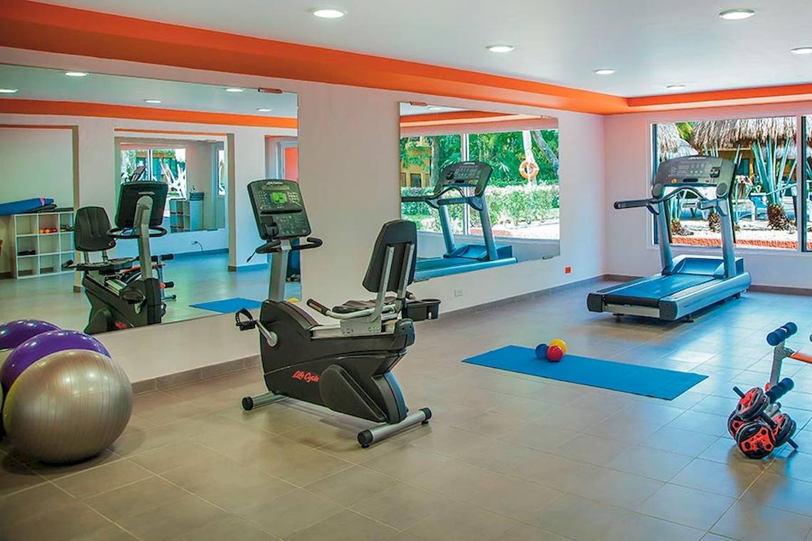 Fitnessstudio im Riu Lupita Hotel mit Laufband, Fahrrad und Hanteln.