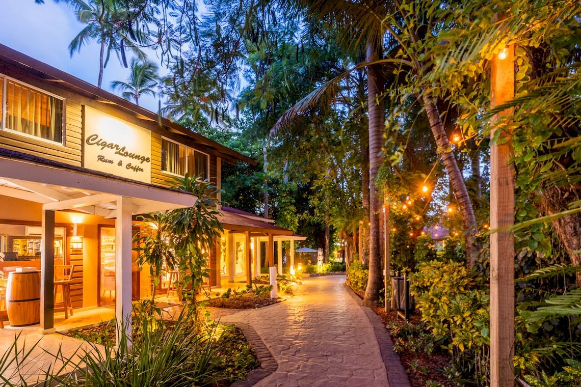 Foto des Eingangsbereichs des Hotels Cigar Lounge Rum & Coffee bei Nacht mit Beleuchtung