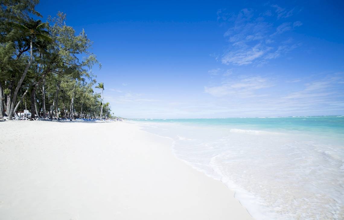 Weißer Sandstrand mit Palmen und blauem Himmel, nahe dem Vista Sol Punta Cana Beach Resort & Spa