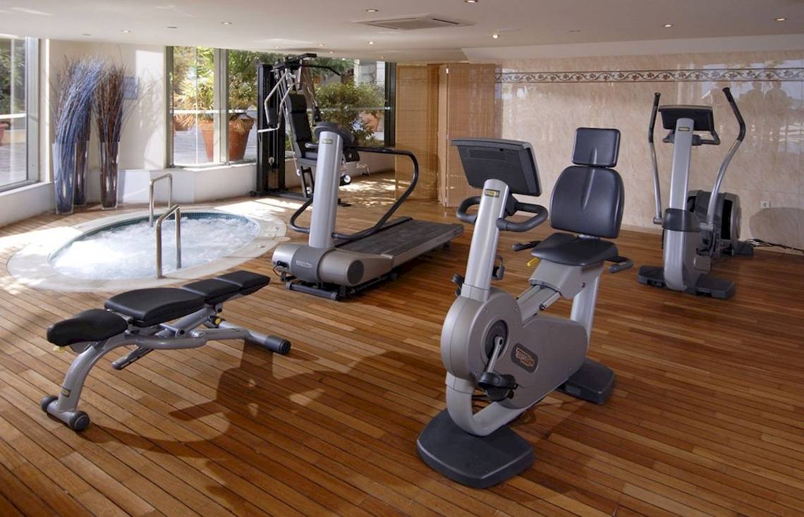 Fitnessbereich im Aquila Porto Rethymno Hotel mit Whirlpool, Laufband und anderen Geräten.