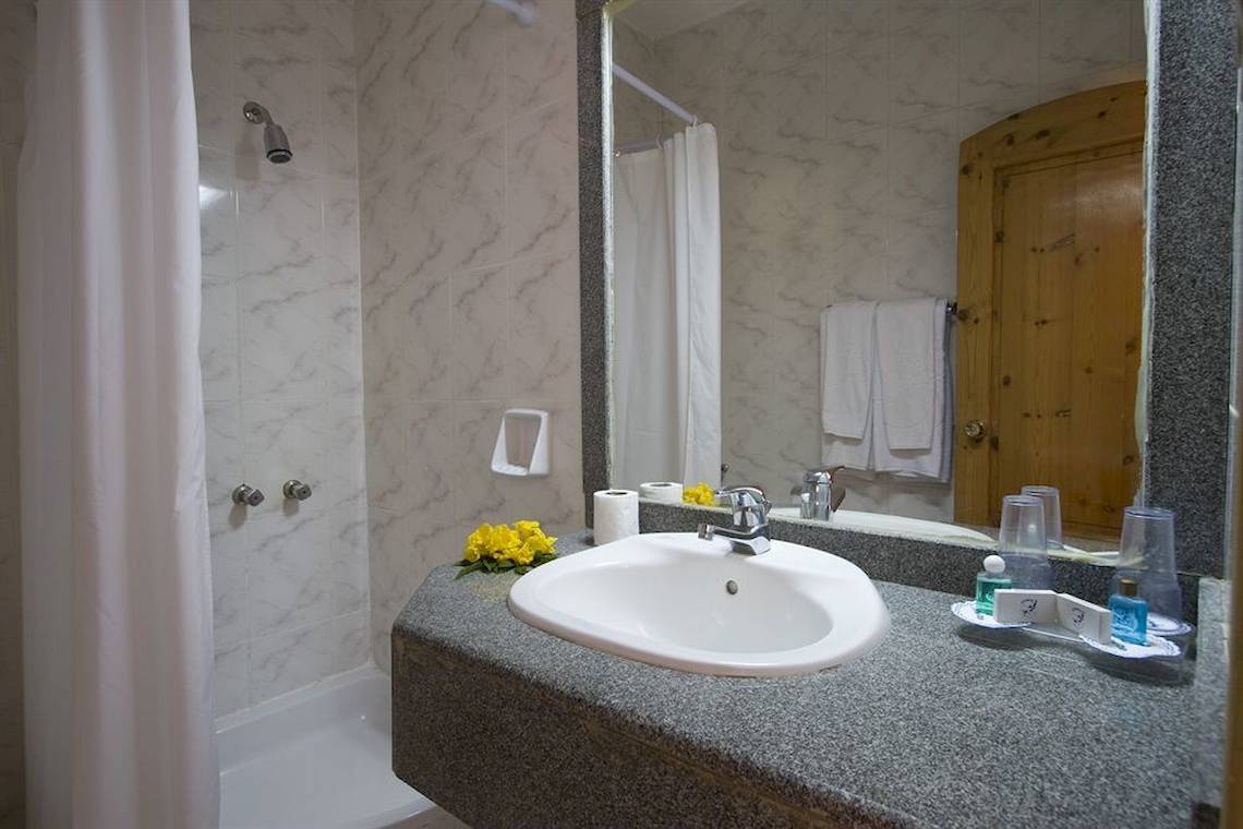 Badezimmer im Utopia Beach Club Hotel mit Waschbecken, Spiegel und Dusche