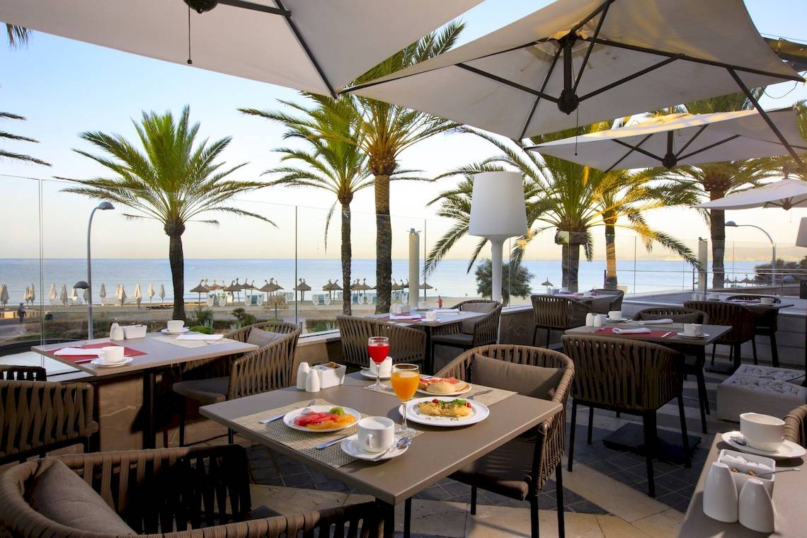 Terrasse des Pure Salt Garonda Hotels mit Blick auf das Meer und Palmen