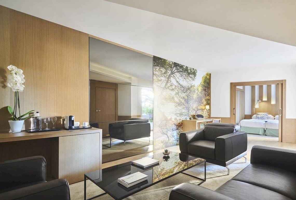 Innenraum des Pure Salt Garonda Hotels mit Wohnzimmer, Schlafbereich und moderner Einrichtung.