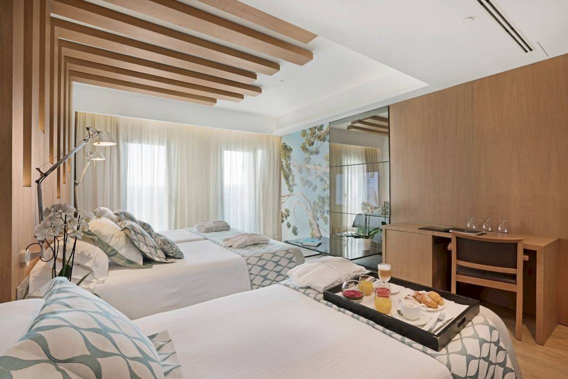 Doppelzimmer im Pure Salt Garonda Hotel mit zwei Betten, Frühstückstablett und Schreibtisch