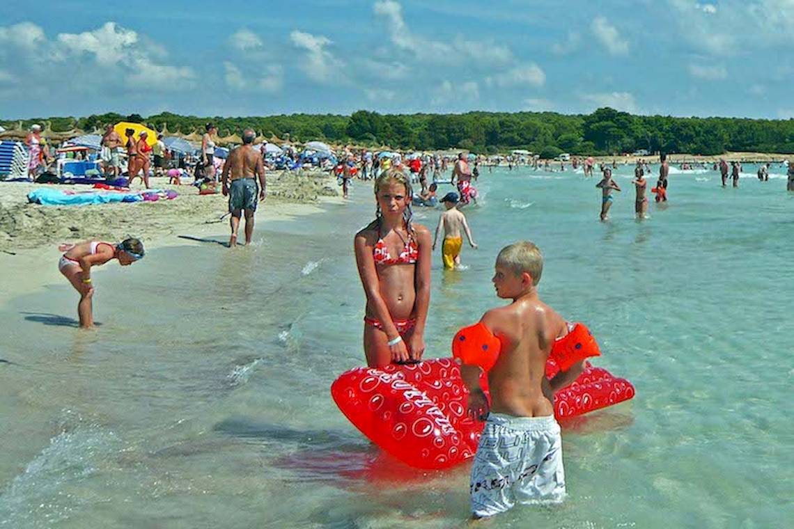 Viele Menschen, die am Strand von Playa Dorada Aparthotel spielen und schwimmen