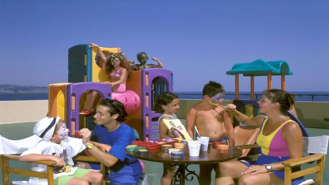 Familie genießt Kinderanimation im Atlantica Nissaki Beach Hotel mit Blick auf das Meer.