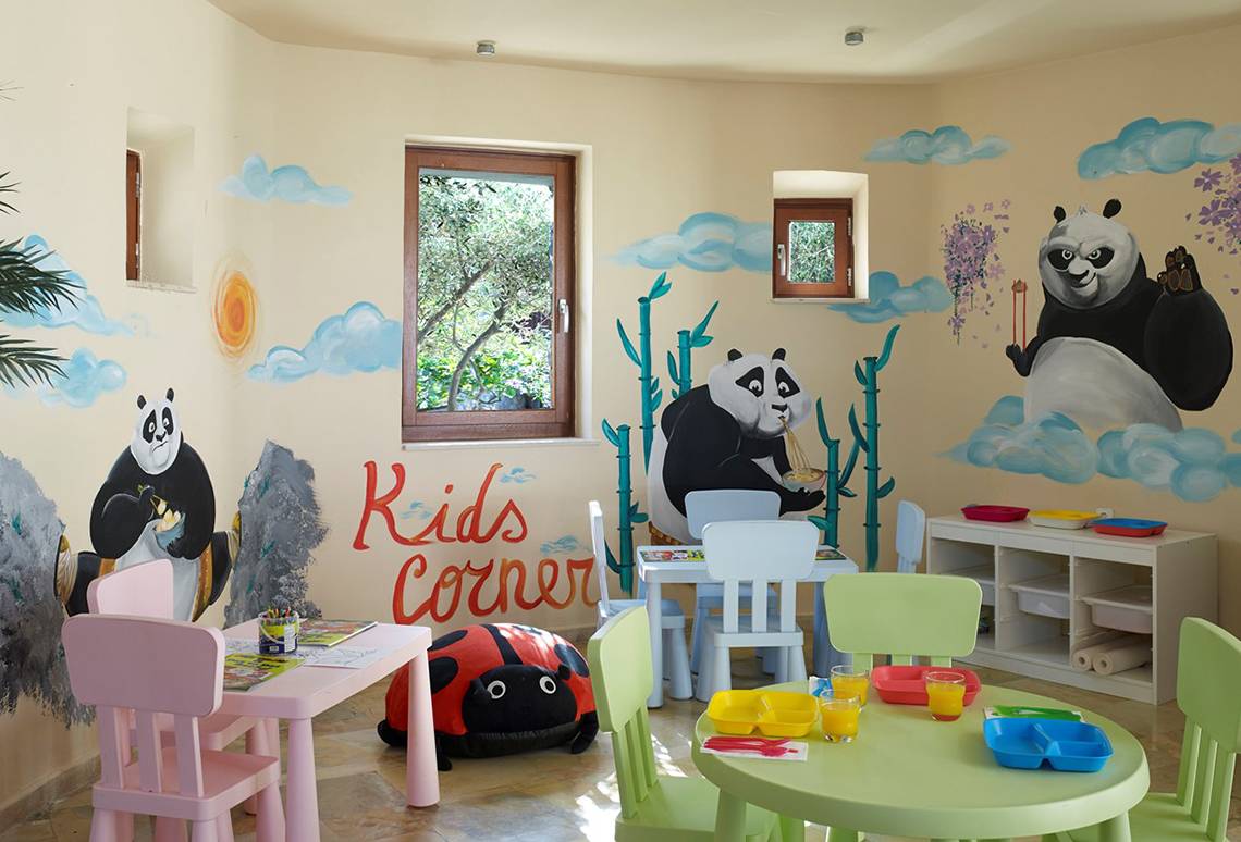 Kinderecke im Ikaros Beach Luxury Resort & Spa mit Panda-Wandmalereien und bunten Möbeln.