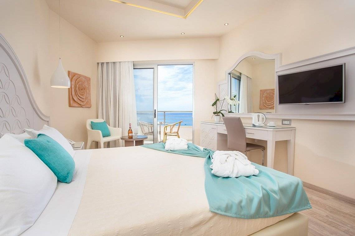 Pegasos Deluxe Beach Hotel Zimmer mit Meerblick, Bett, Sessel, Schreibtisch und Fernseher.