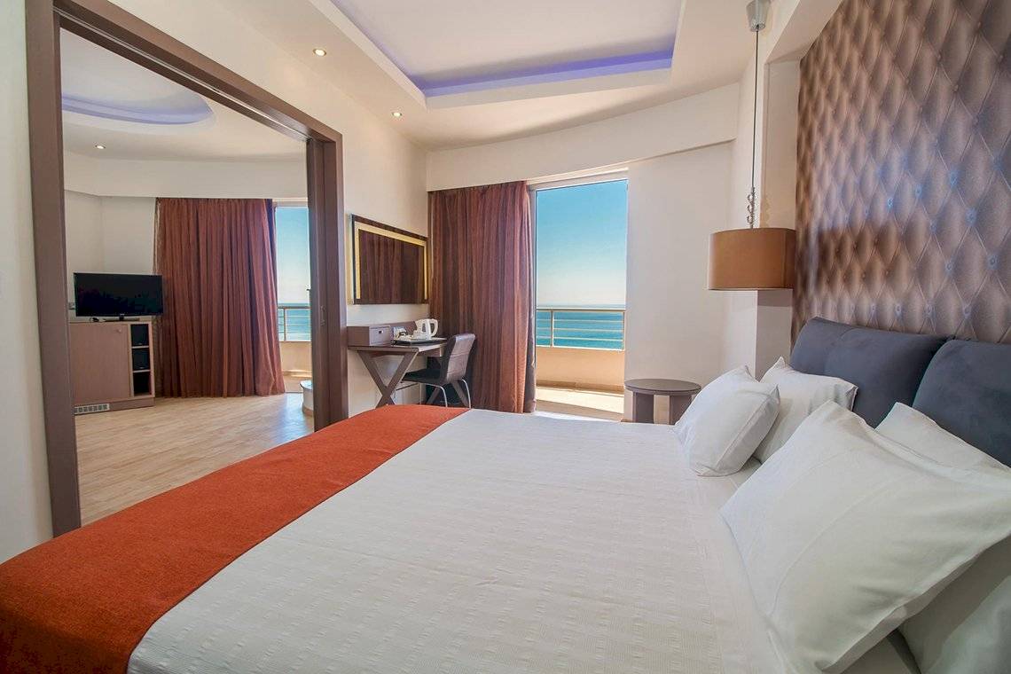 Innenansicht eines Schlafzimmers im Pegasos Deluxe Beach Hotel mit Meerblick.