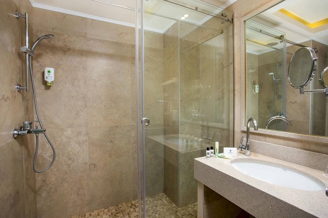 Badezimmer im Pegasos Deluxe Beach Hotel mit Dusche und Waschbecken.