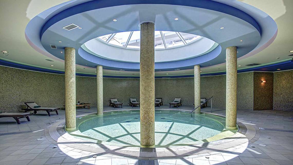 Wellnessbereich im Atlantica Marmari Palace mit Pool und Liegen