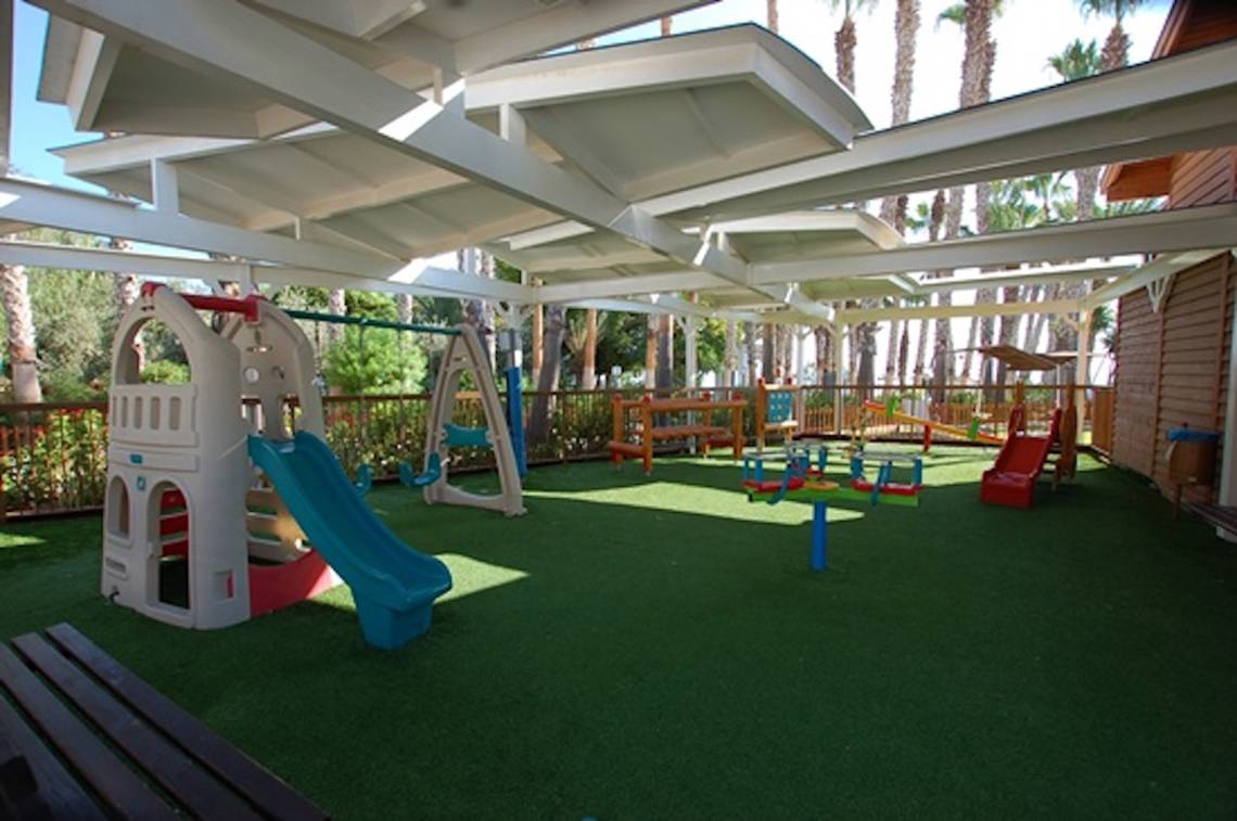 Kinderspielplatz im Cavo Maris Beach Hotel mit Rutsche und Schaukeln.