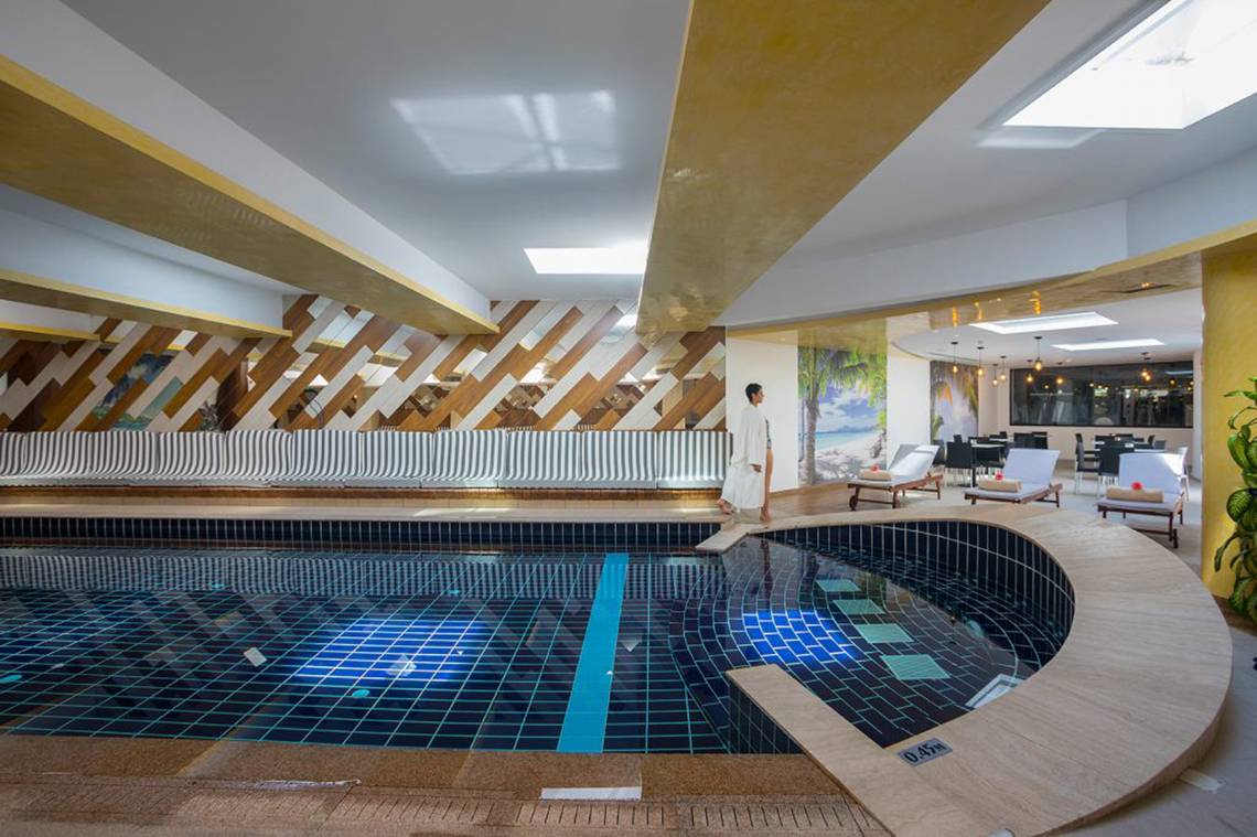 Person am Rand des Innenpools im Cavo Maris Beach Hotel