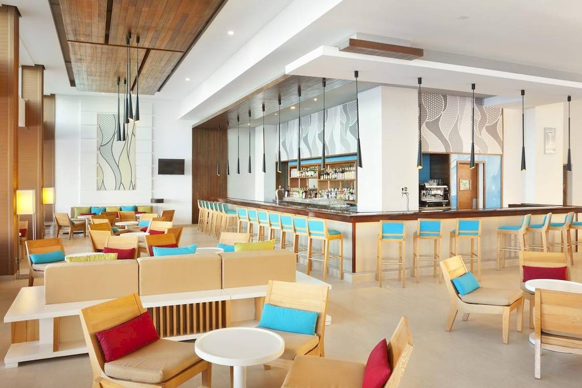 Innenbereich der Bar und Lounge im Hotel Playa Vista Azul in Varadero mit bunten Stühlen und Tischen.