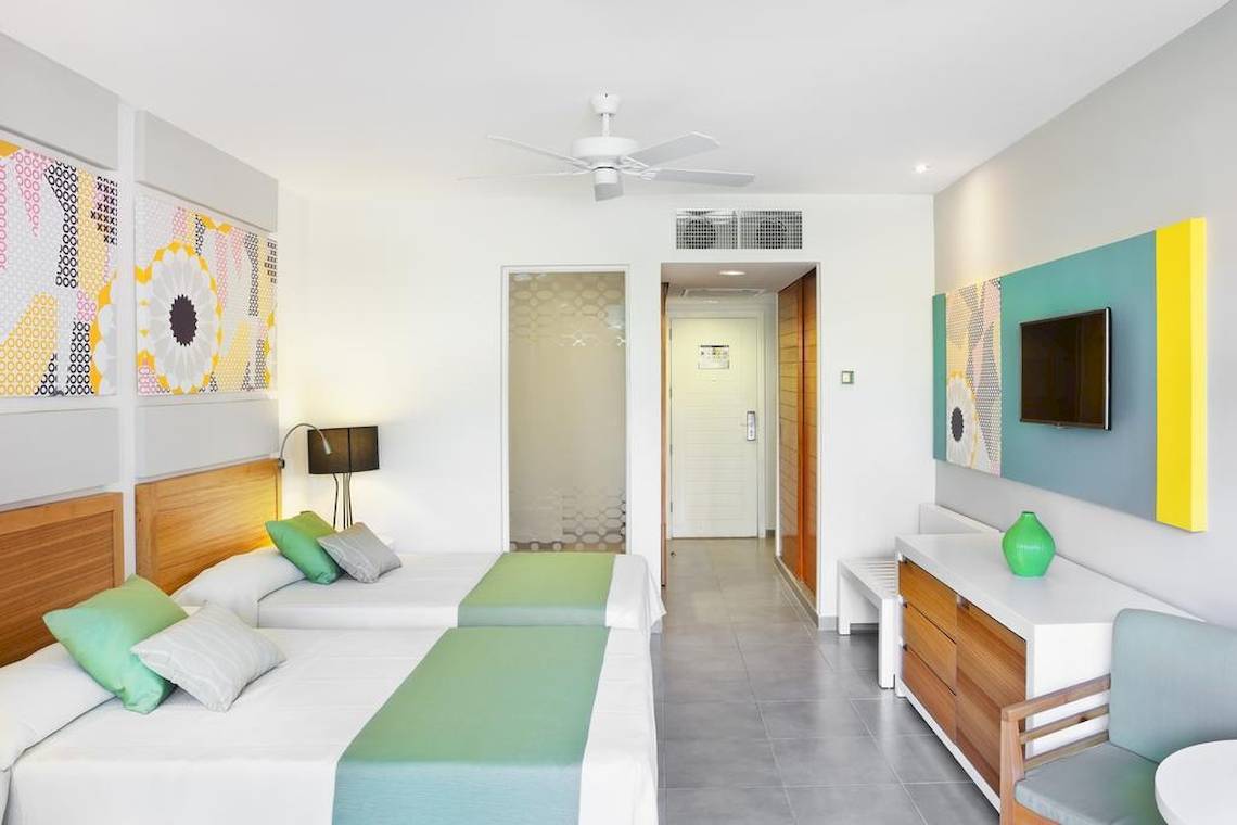 Doppelbett-Zimmer im Playa Vista Azul Hotel in Varadero mit bunten Wandbildern und moderner Einrichtung.