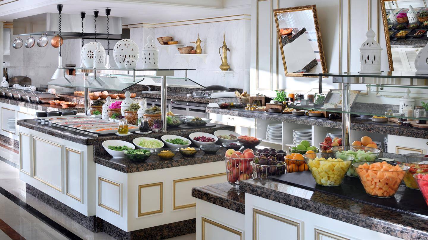 Buffet-Tisch im Kempinski Hotel Residences Palm Jumeirah mit verschiedenen Salaten und Früchten.