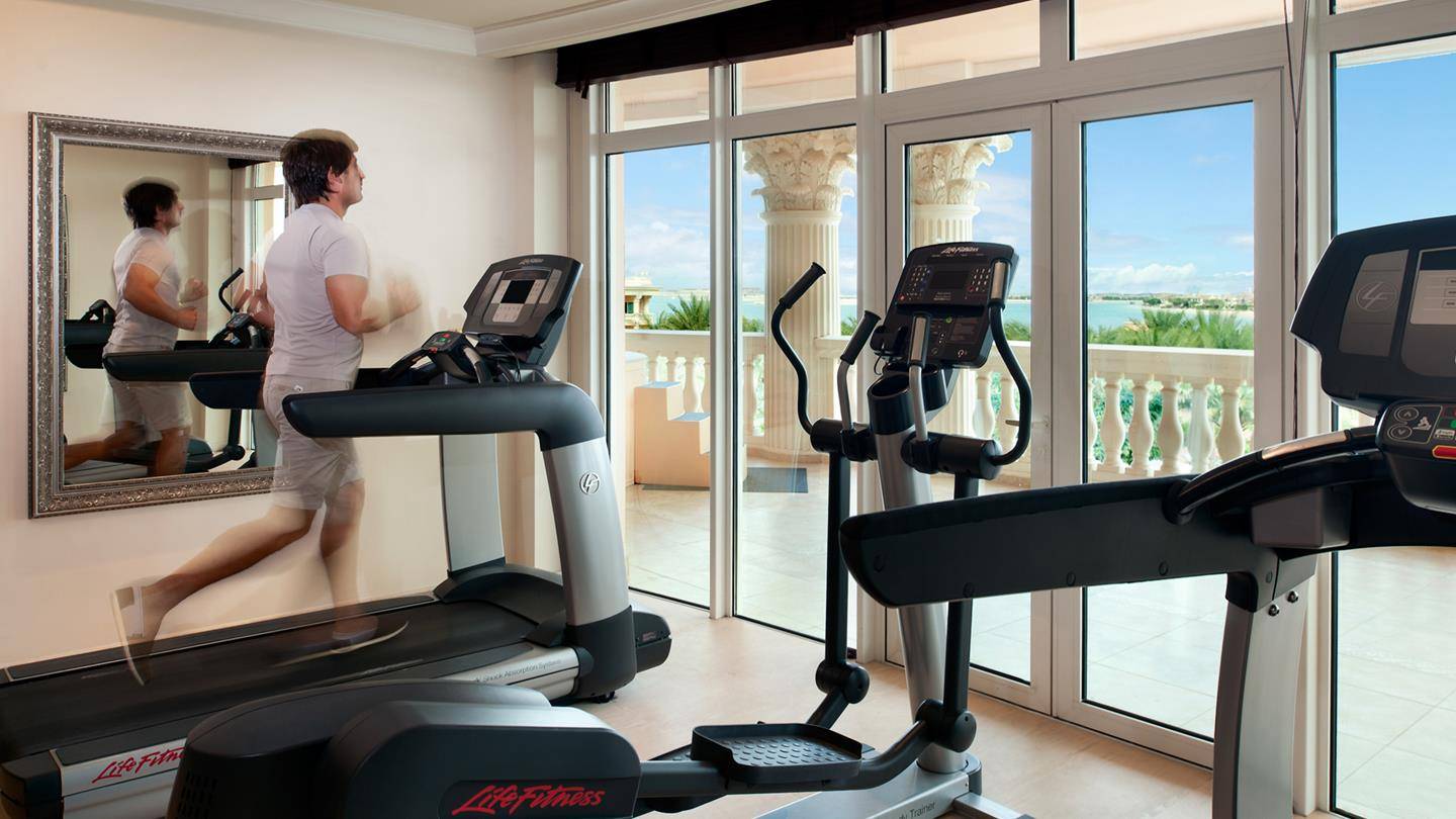 Fitnessstudio im Kempinski Hotel Residences Palm Jumeirah mit Läufer auf Laufband und Aussicht auf Meer