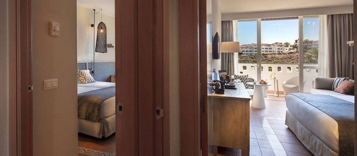 Innenansicht eines Hotelzimmers im Fuerteventura Princess mit Blick auf die Außenterrasse und die Landschaft.