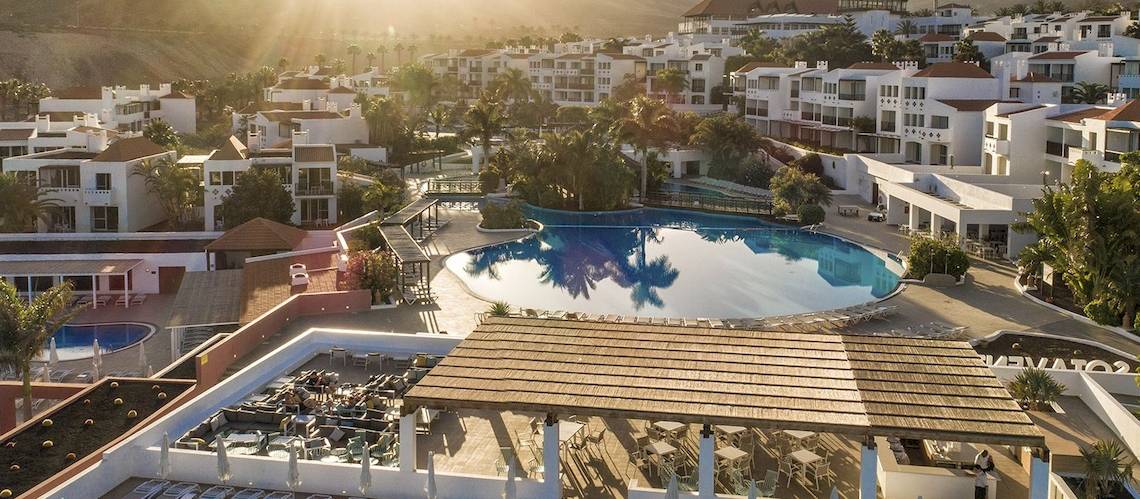 Luftaufnahme des Fuerteventura Princess Hotels mit Swimmingpool und Sonnenuntergang im Hintergrund.