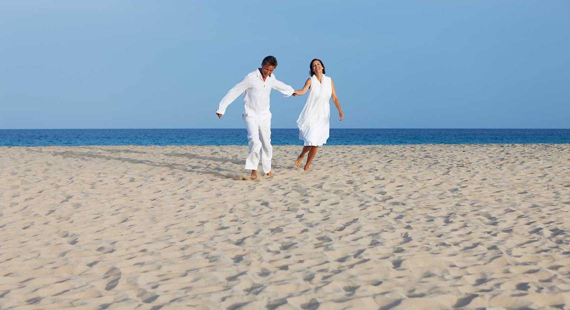 Ein Paar läuft auf dem Strand im Occidental Jandia Royal Level Hotel