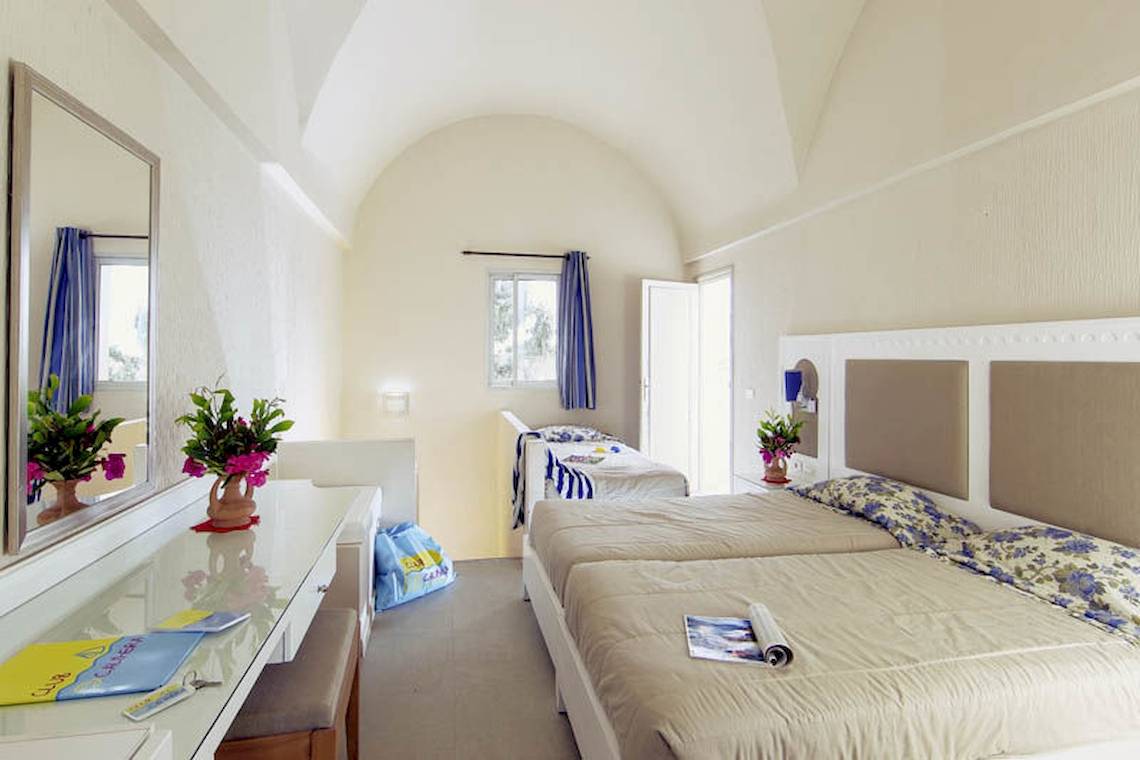 Doppelzimmer im Calimera Yati Beach Hotel mit zwei Betten, Dekor und Möbeln.