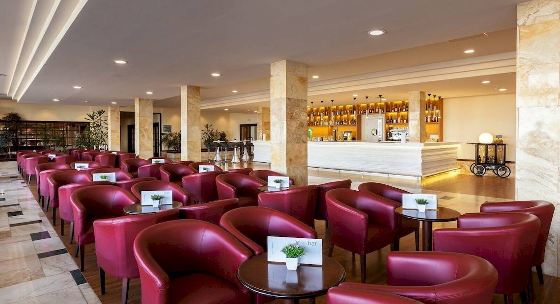 Hotellounge Bereich im Occidental Jandia Mar mit roten Lederstühlen und Tischen.