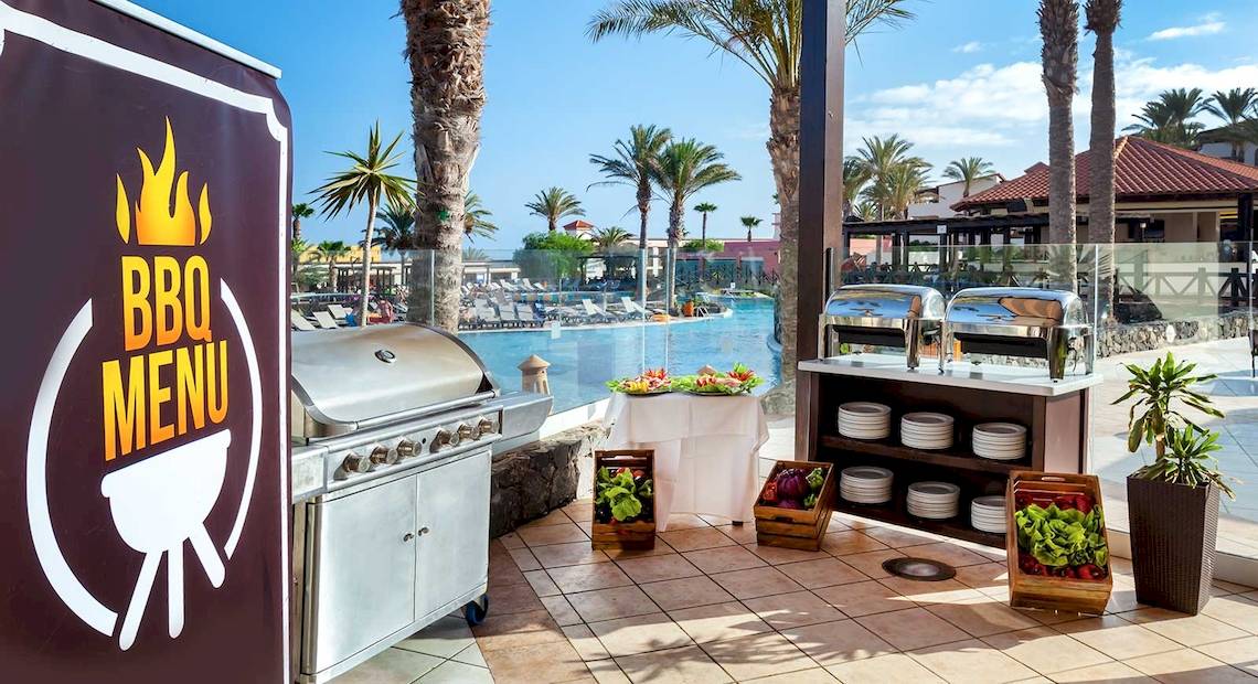 BBQ-Grill im Occidental Jandia Mar Hotel mit Blick auf den Pool und die Palmen.