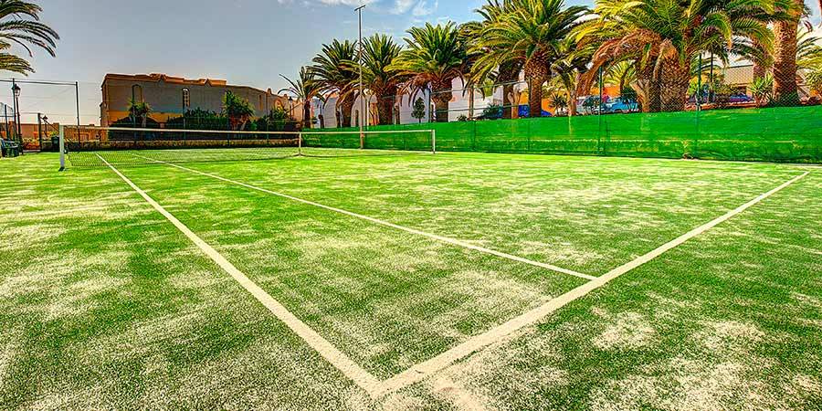 Tennisplatz im Freien mit weißem Sand und grünem Kunstrasen im SBH Monica Beach Resort