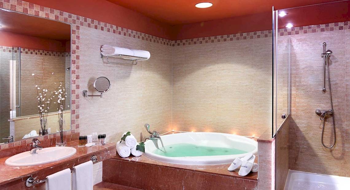 Badezimmer im Occidental Jandia Royal Level mit Badewanne, Dusche und Spiegel.