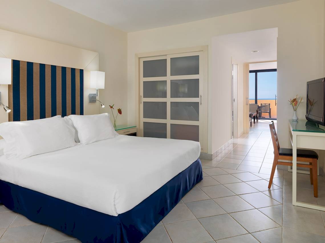 Ein modernes Zimmer im H10 Tindaya Hotel mit einem Bett und einem Arbeitsbereich.