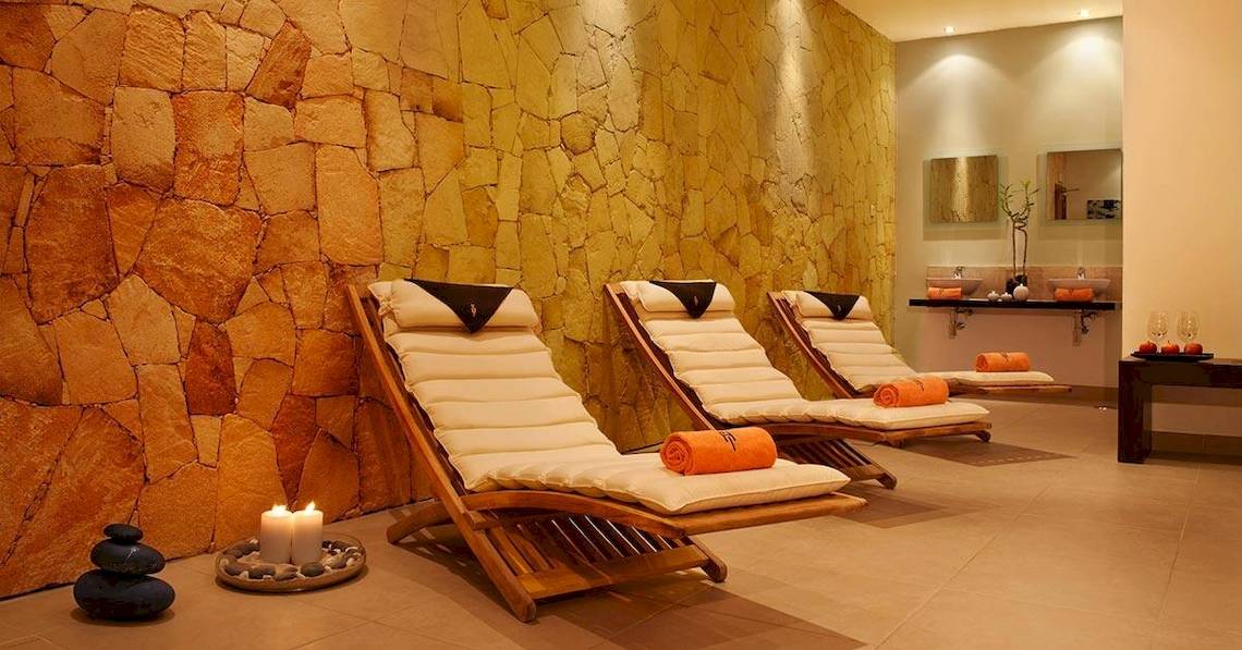 Spa-Lounge im Melia Tortuga Beach Hotel mit drei Liegestühlen und Kerzen.