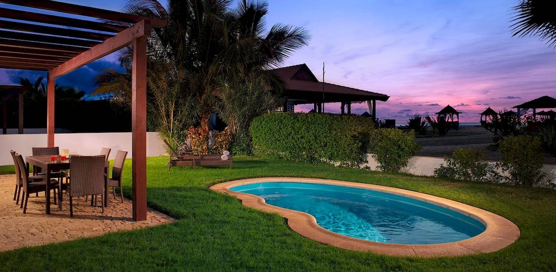 Außenbereich des Melia Tortuga Beach Hotels mit einem kleinen Pool bei Sonnenuntergang.
