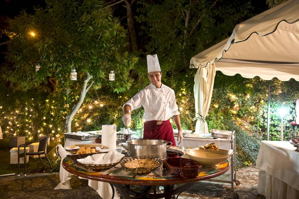 Ein Koch im Sierra Silvana Hotel bereitet ein Essen unter freiem Himmel in der Nacht zu.