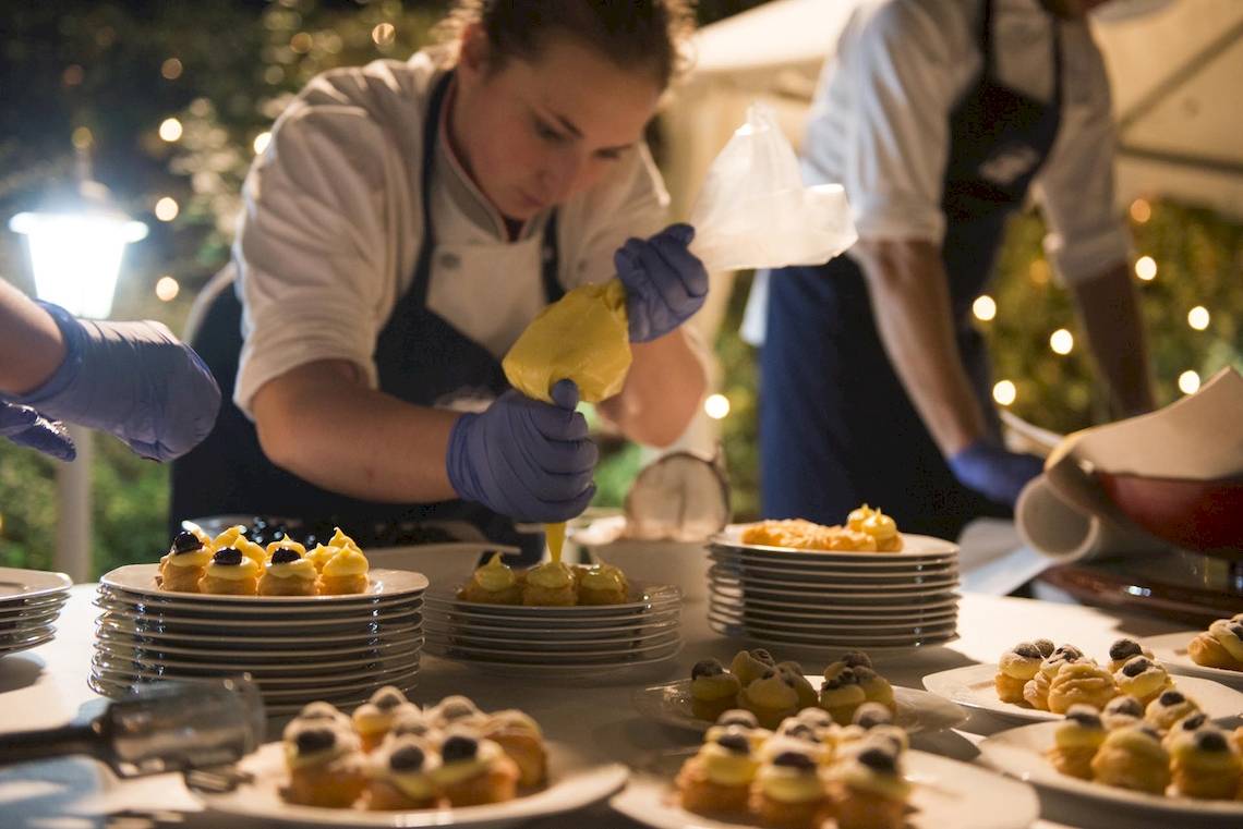 Küchenteam des Sierra Silvana Hotels bei der Arbeit, mehrere Platten mit Desserts werden zubereitet.