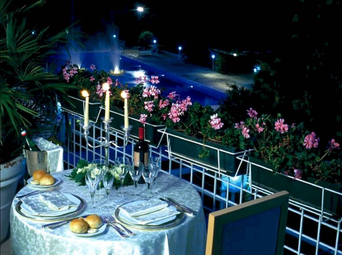 Ein elegantes Abendessen auf der Terrasse des Sierra Silvana Hotels mit Kerzen und Blick auf den Pool.