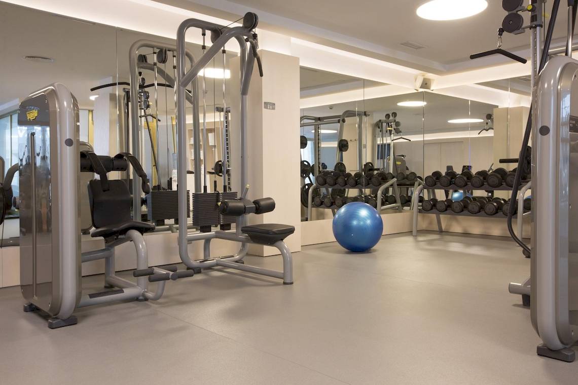 Fitnessstudio im Hipotels Hipocampo Palace mit modernen Geräten und blauem Medizinball.