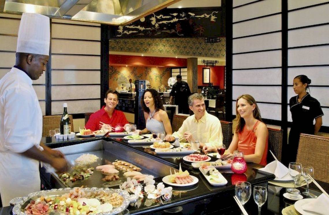 Sushi-Buffet im Bahia Principe Grand Bavaro Hotel mit Gästen und einem Koch.