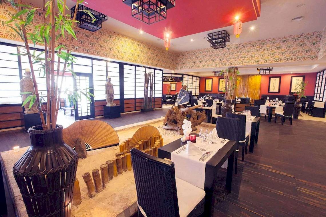 Innenbereich des Restaurants im Bahia Principe Grand Bavaro Hotel mit Tischdekoration und asiatischem Dekor