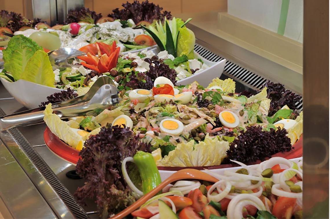 Buffet mit verschiedenen Salaten und Gemüse in weißen Schüsseln im Nelia Beach Hotel & Spa.