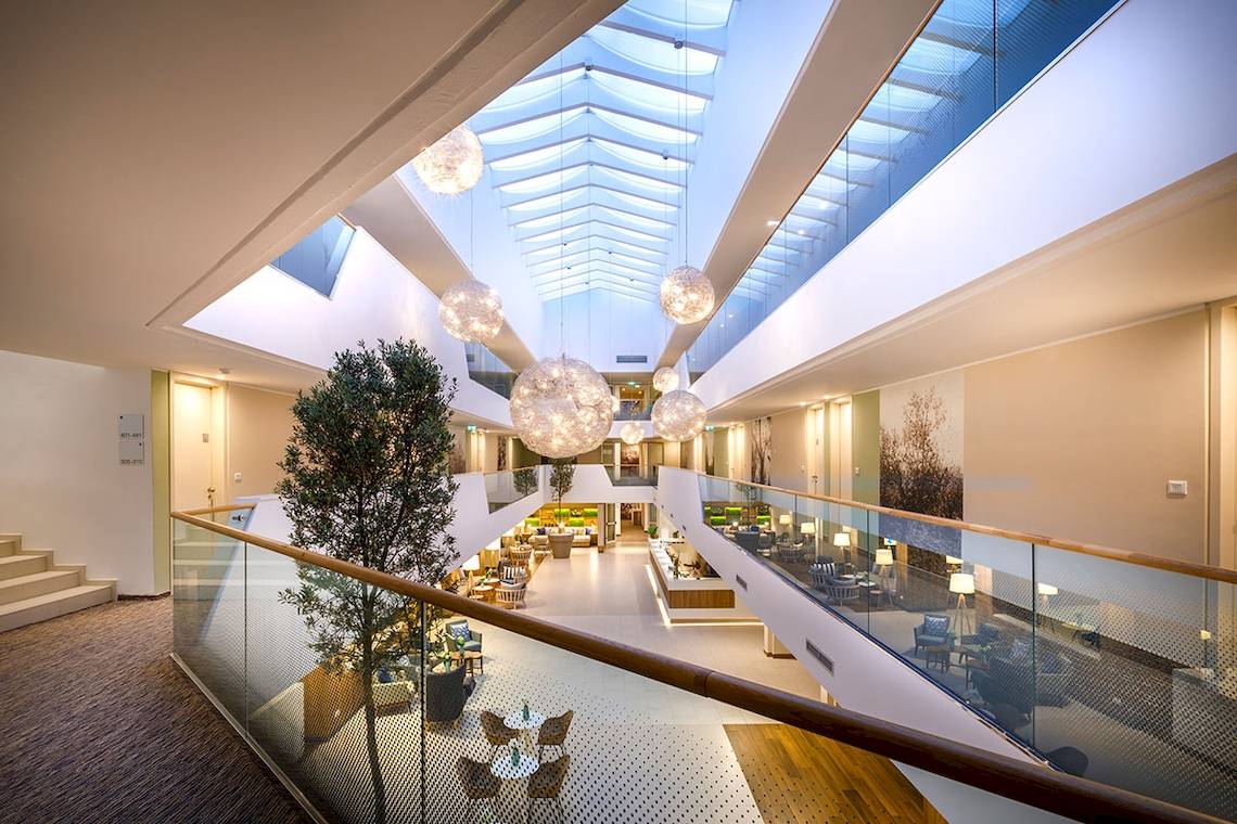 Innenbereich des Valamar Argosy Hotels mit hoher Lobby, heller Beleuchtung und hängenden Leuchten.