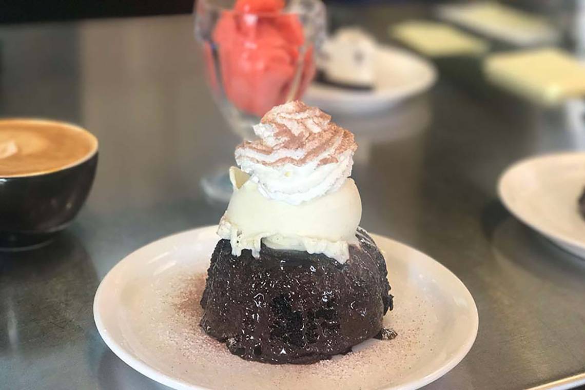 Ein Schokoladen-Lava-Kuchen mit Eis auf einem weißen Teller.