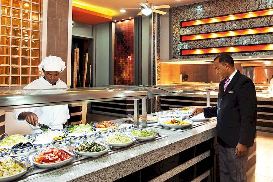 Ein Kellner serviert ein Buffet im Riu Naiboa Hotel.