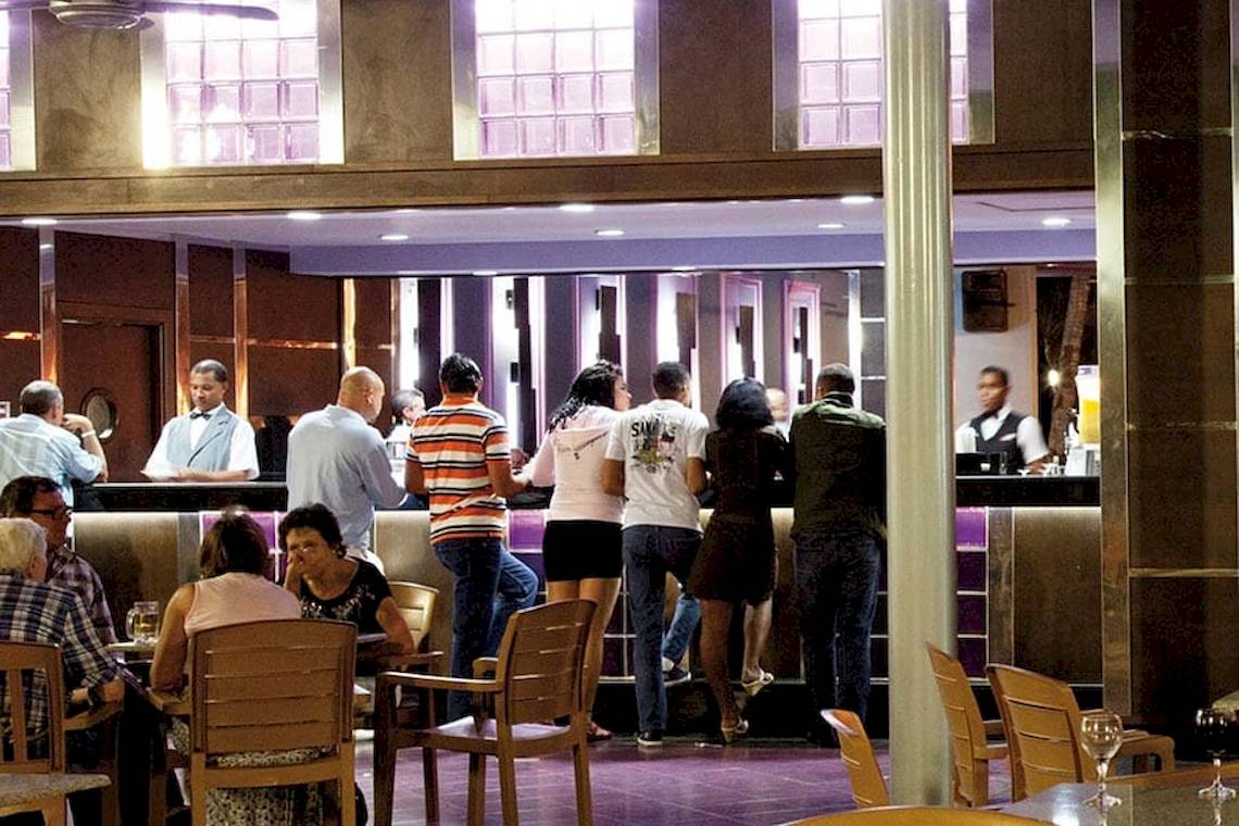 Gäste stehen an der Bar des Riu Naiboa Hotels