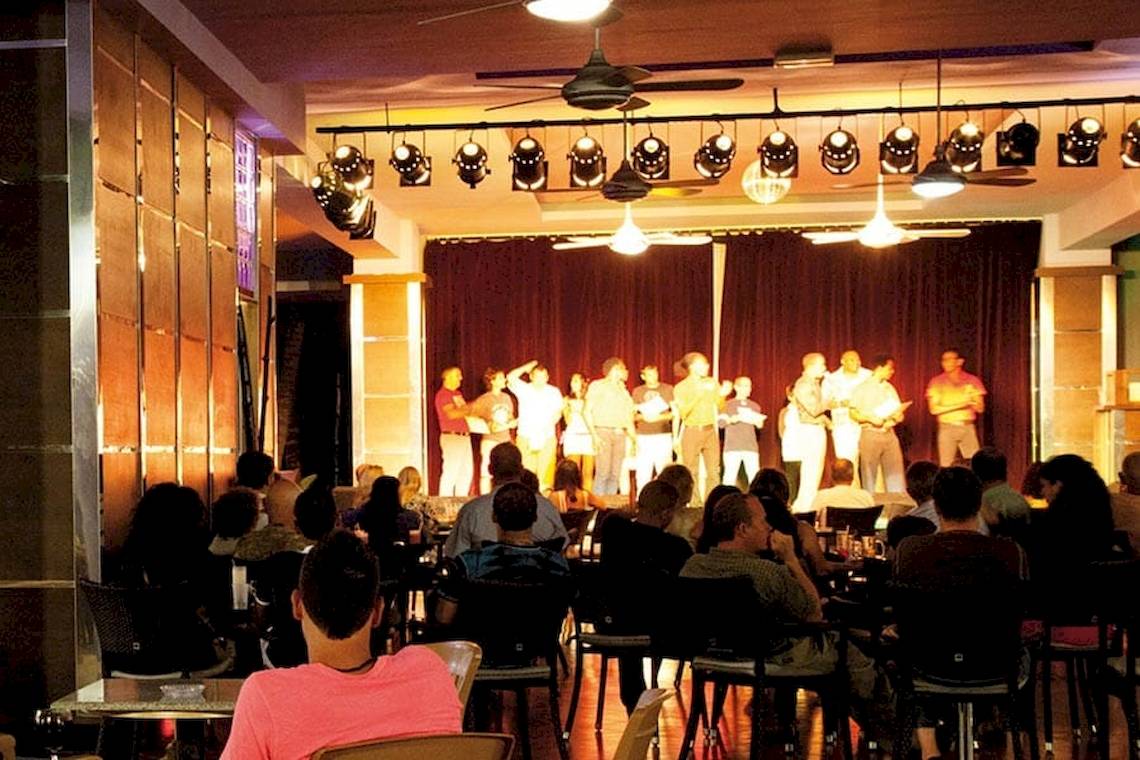 Live-Musik im Restaurant des Riu Naiboa Hotels mit einer Gruppe von Musikern und Gästen, die zuhören.